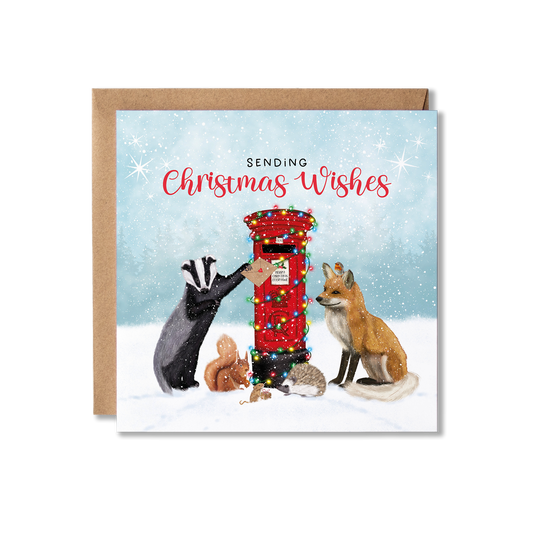 British woodland animals Christmas card featuring a Badger, Fox, Squirrel, Mouse, Hedgehog and a Robin posting a Christmas card at a red post box decorated in Christmas lights.