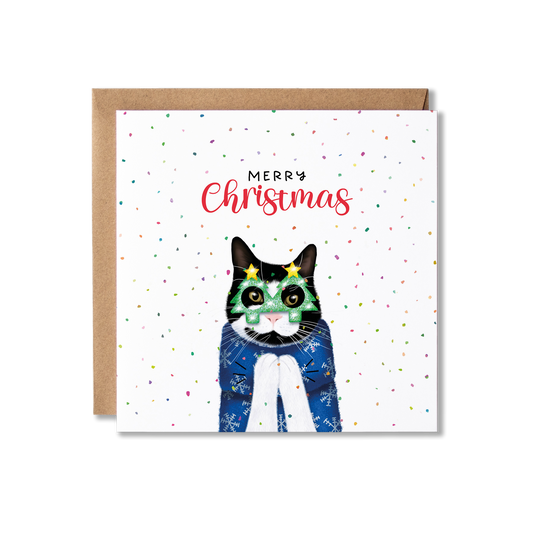 Black and white cat in a Christmas jumping clapping, with Christmas tree shape glasses on, surrounded by confetti and Merry Christmas above.